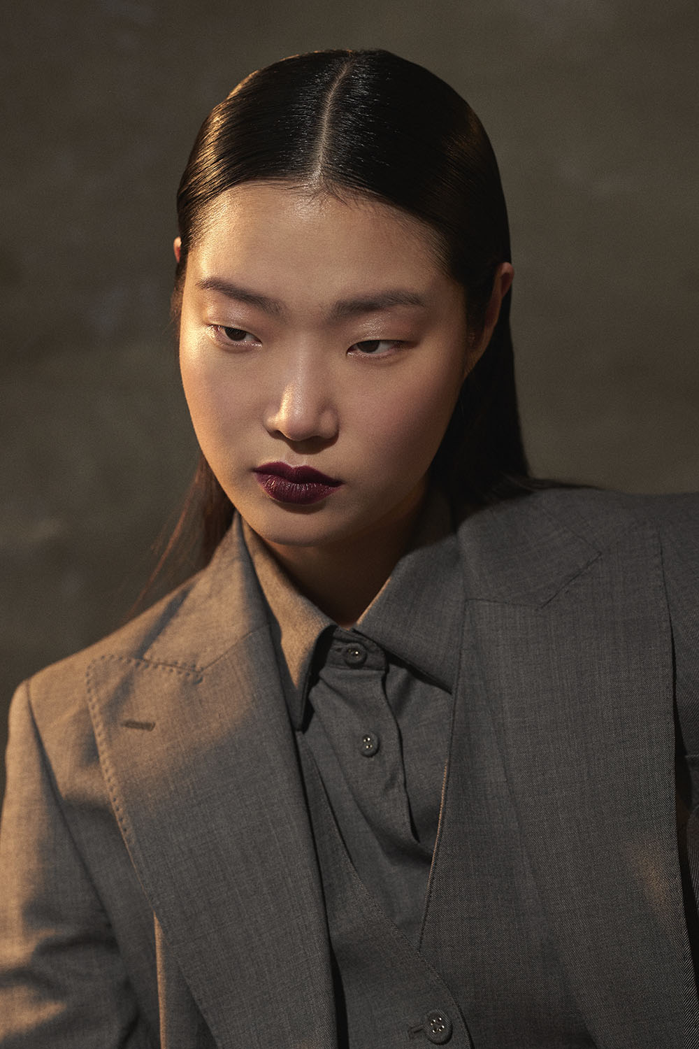NYC fashion editorial-Close-up of model in tailored gray suit with dark lipstick, studio editorial portrait by Vikram Pathak