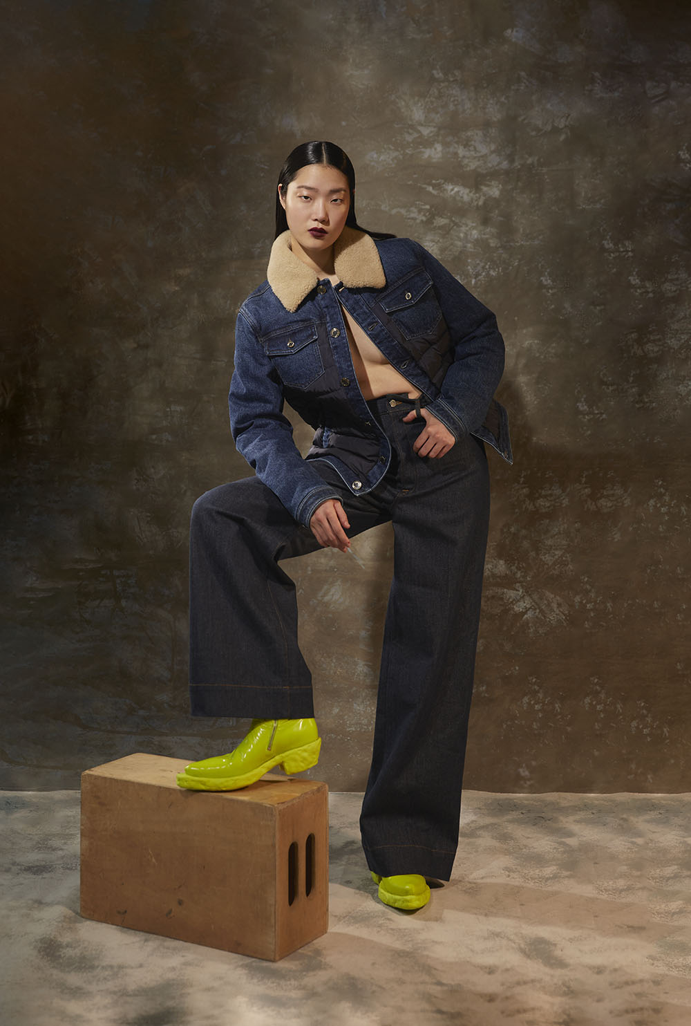 Fashion Photographer in new york - Model in dark denim outfit with shearling collar jacket and neon shoes in studio fashion editorial by Vikram Pathak 
