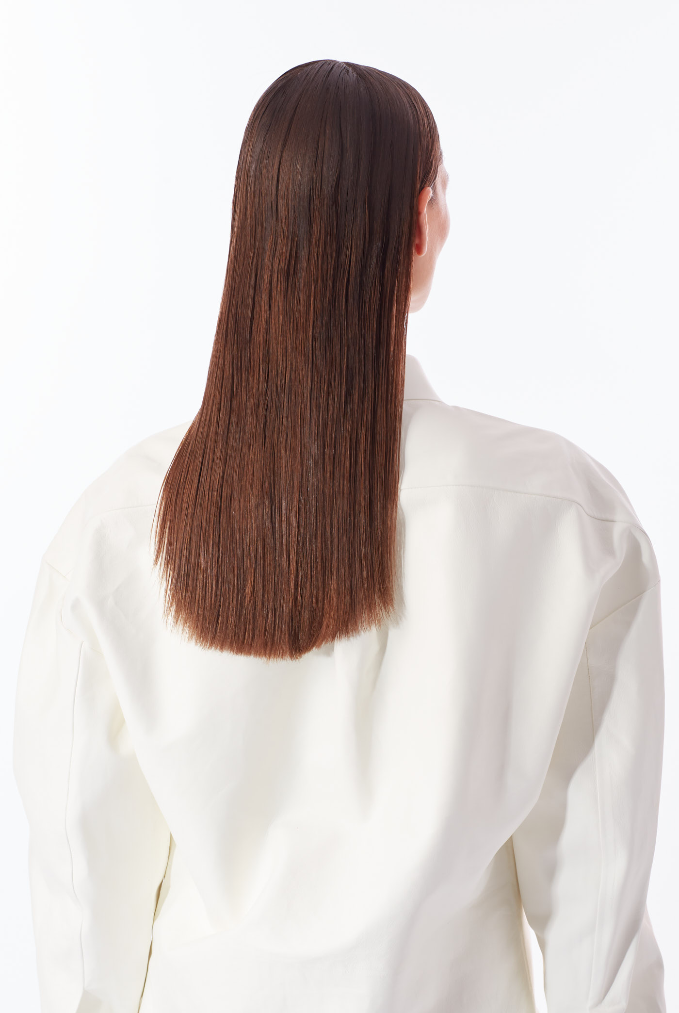 Back view of model with sleek straight brown hair in oversized white shirt – New York fashion editorial