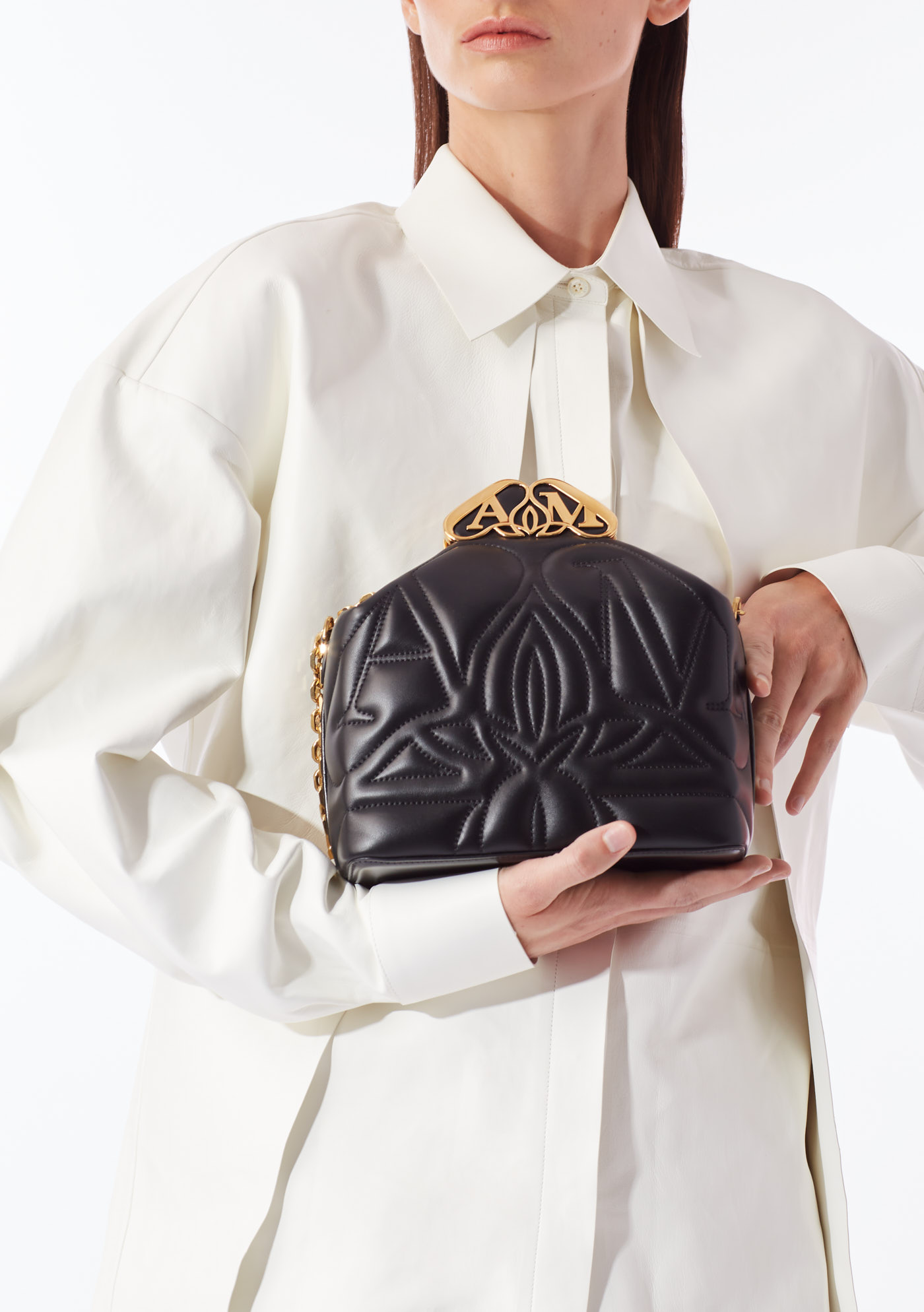 Model holding quilted black designer handbag with gold clasp during New York editorial photoshoot