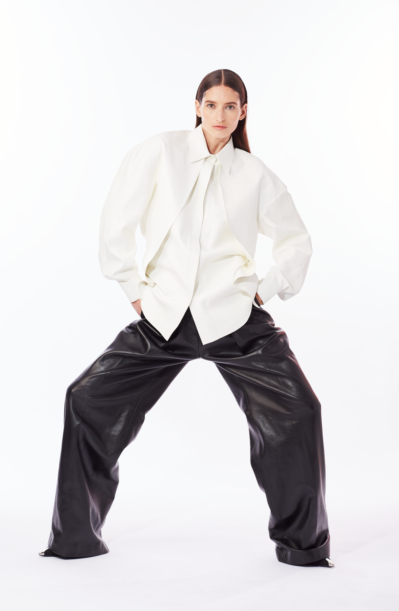 Model in oversized white shirt and wide-leg leather pants posing for NYC fashion editorial photoshoot