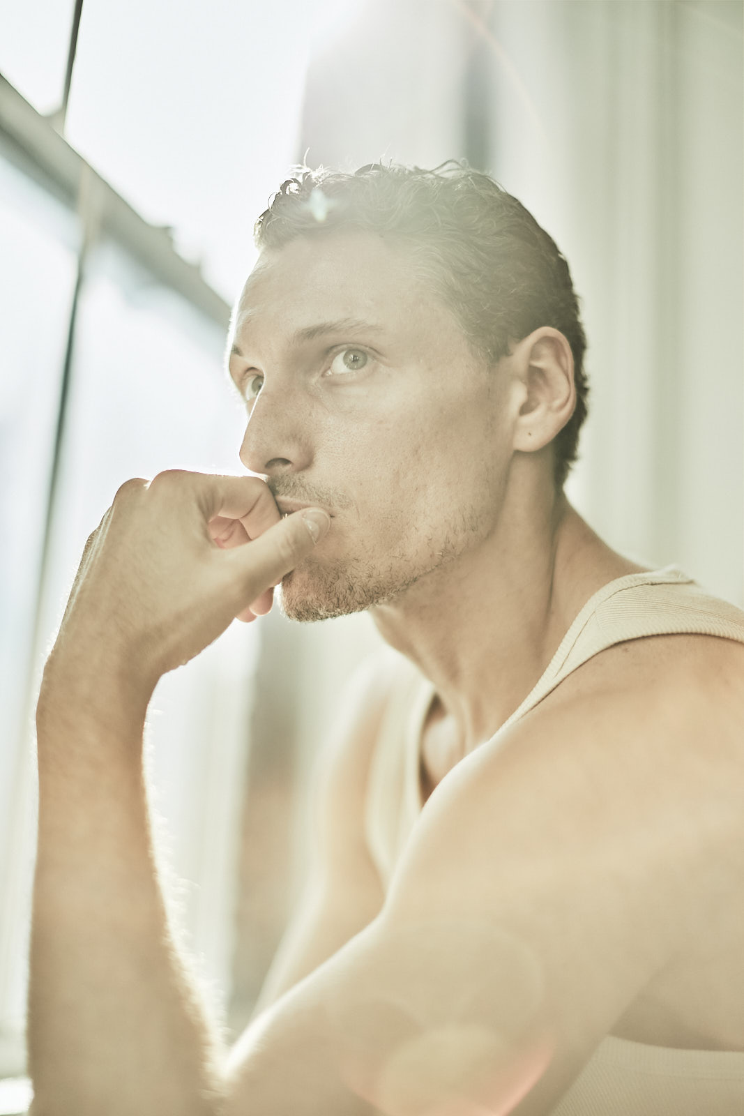 Editorial portrait of a male model in soft window light by New York men’s fashion photographer Vikram Pathak