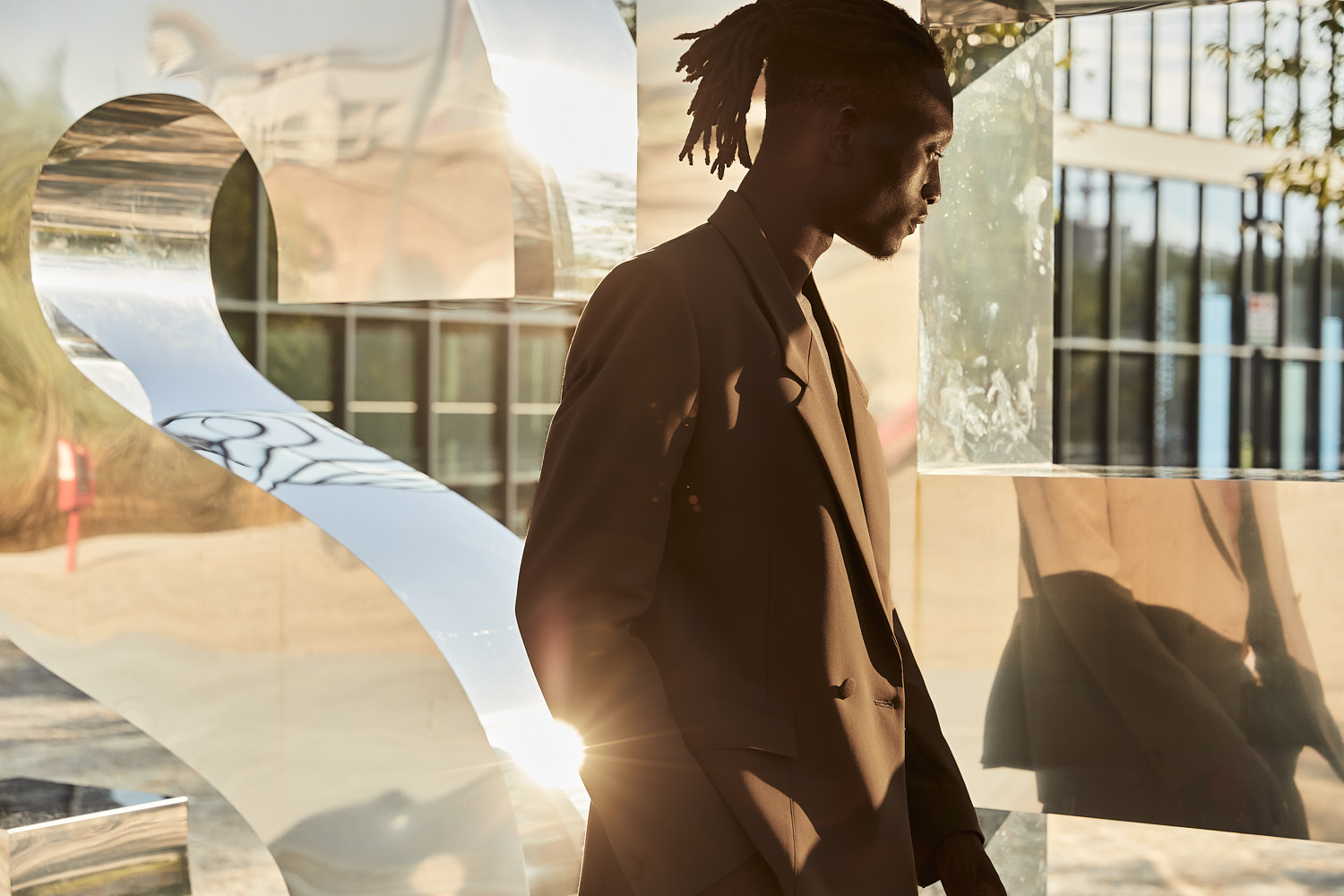 Male model in brown suit under sunlight, photographed by Vikram Pathak in NYC.