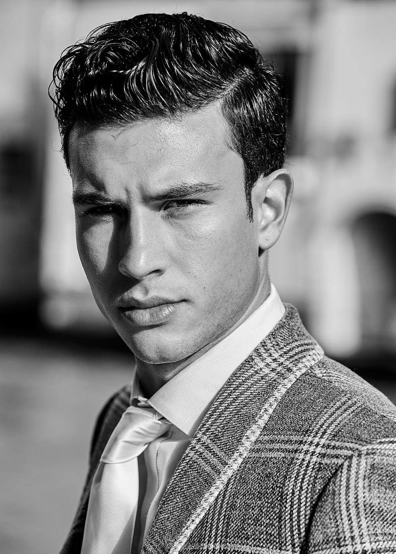 Monochrome close-up portrait of a male model in plaid suit.