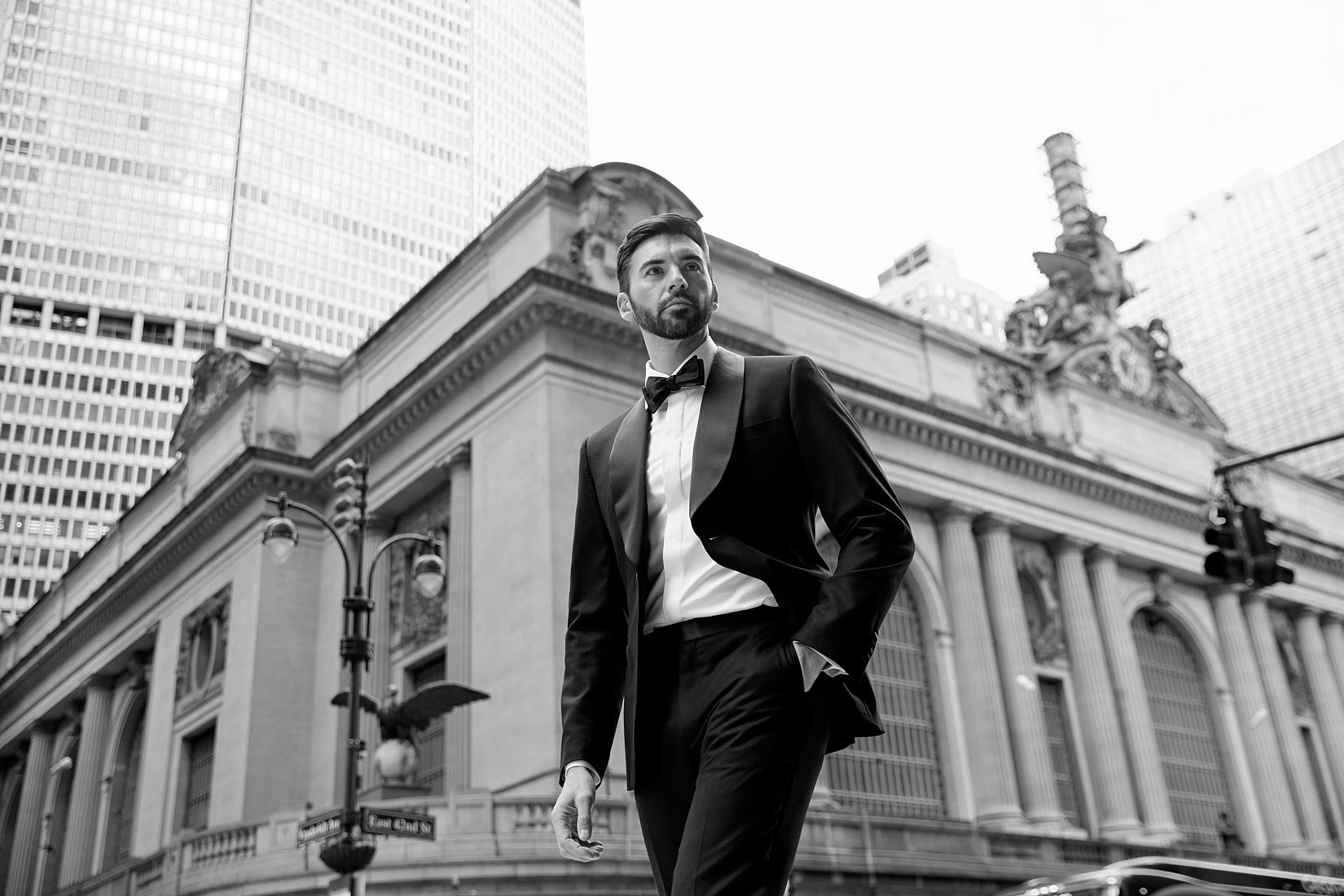 Male model in tuxedo standing outside Grand Central Station NYC in black and white editorial photograph