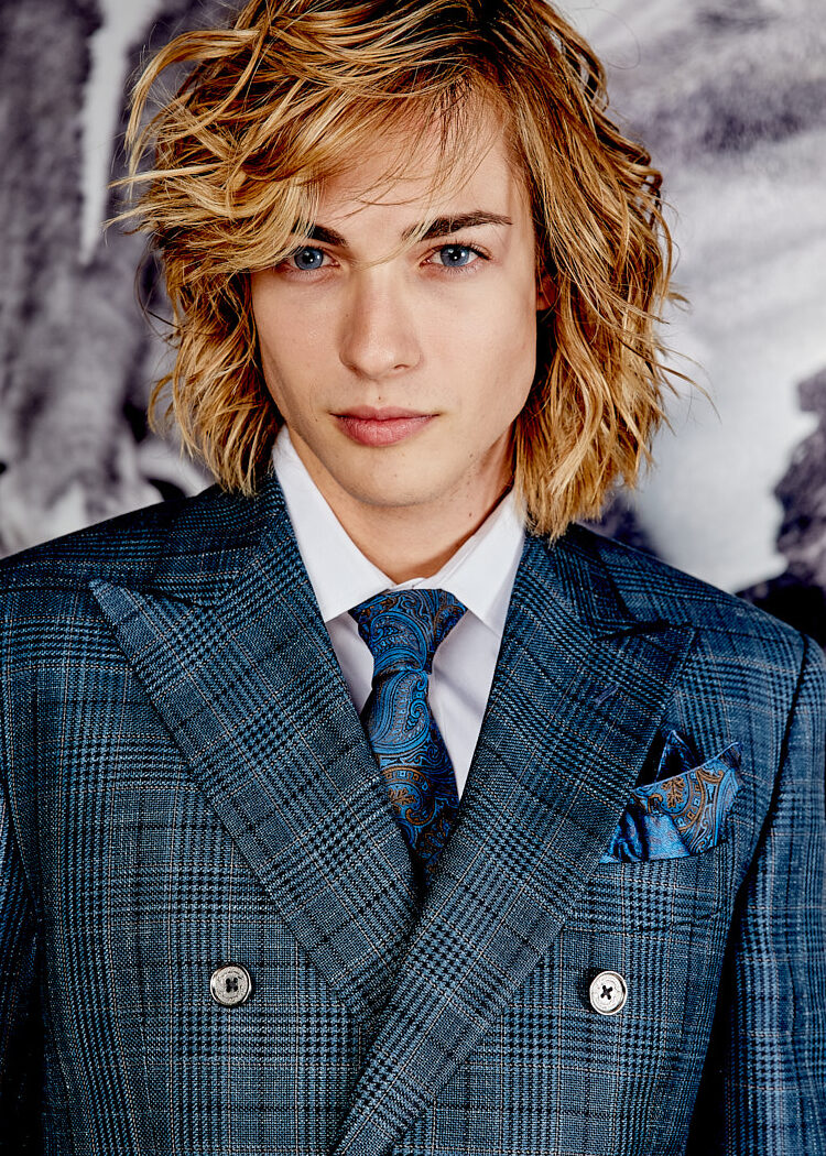 Close-up of male model in blue plaid double-breasted suit with paisley tie, photographed in New York by Vikram Pathak.