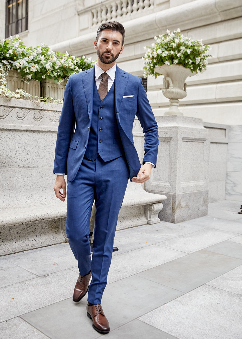 Male model in blue tailored suit walking toward camera in NYC during fashion shoot by Vikram Pathak