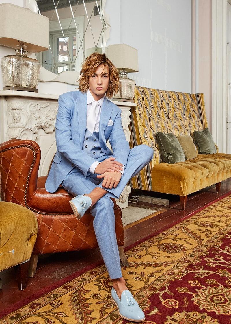 Male model seated in powder-blue suit, New York menswear editorial by Vikram Pathak.