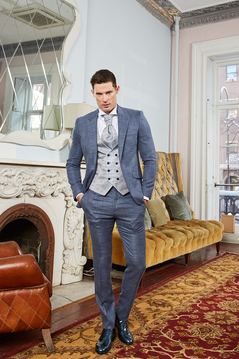 Model wearing grey-blue check suit in New York apartment setting, shot by fashion photographer Vikram Pathak
