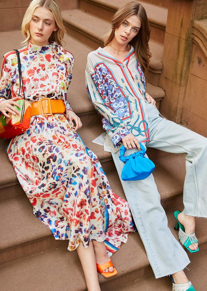 Two models seated on urban stairs in floral fashion during a commercial photo session