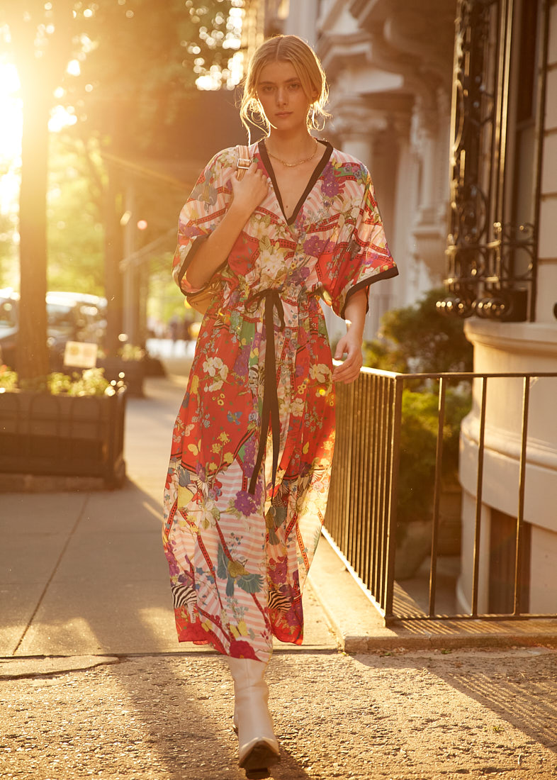 Fashion model walking in sunset light wearing floral print dress during a commercial shoot