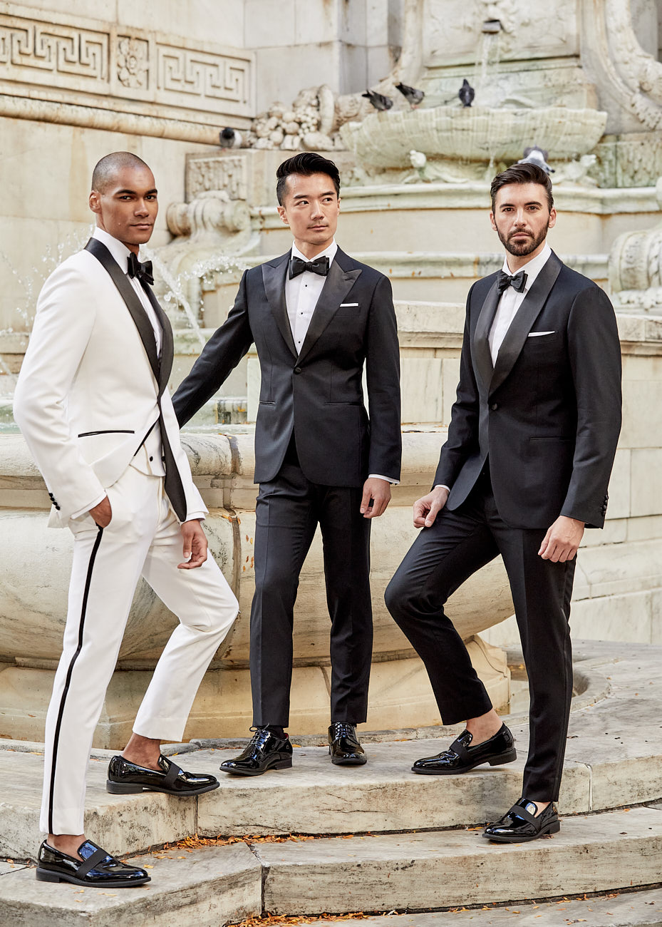 Three male models in black and white tuxedos at a NYC fountain during editorial shoot by Vikram Pathak