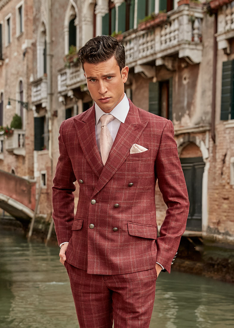 Man wearing red double-breasted suit near Venetian bridge